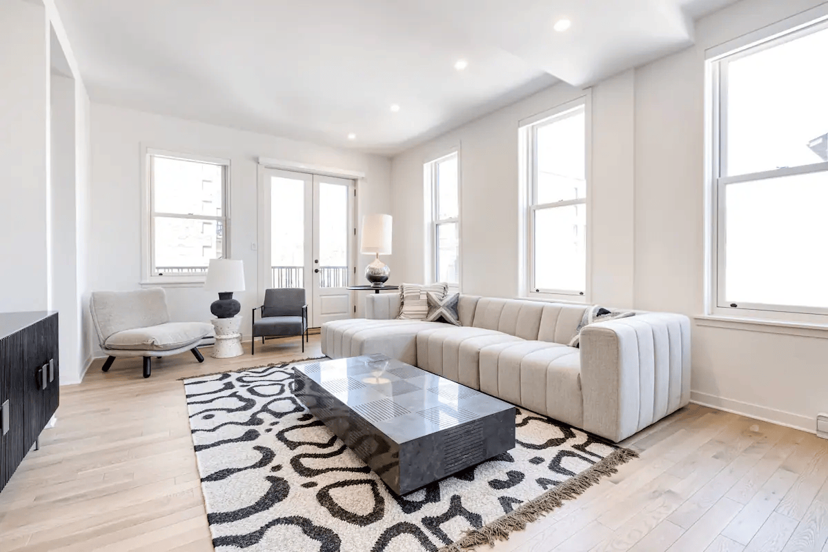 Modern living room with beige sectional sofa and patterned rug
