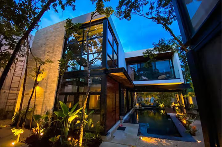 Modern villa exterior with pool at dusk