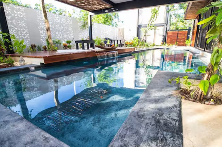 Indoor pool with wooden deck and greenery